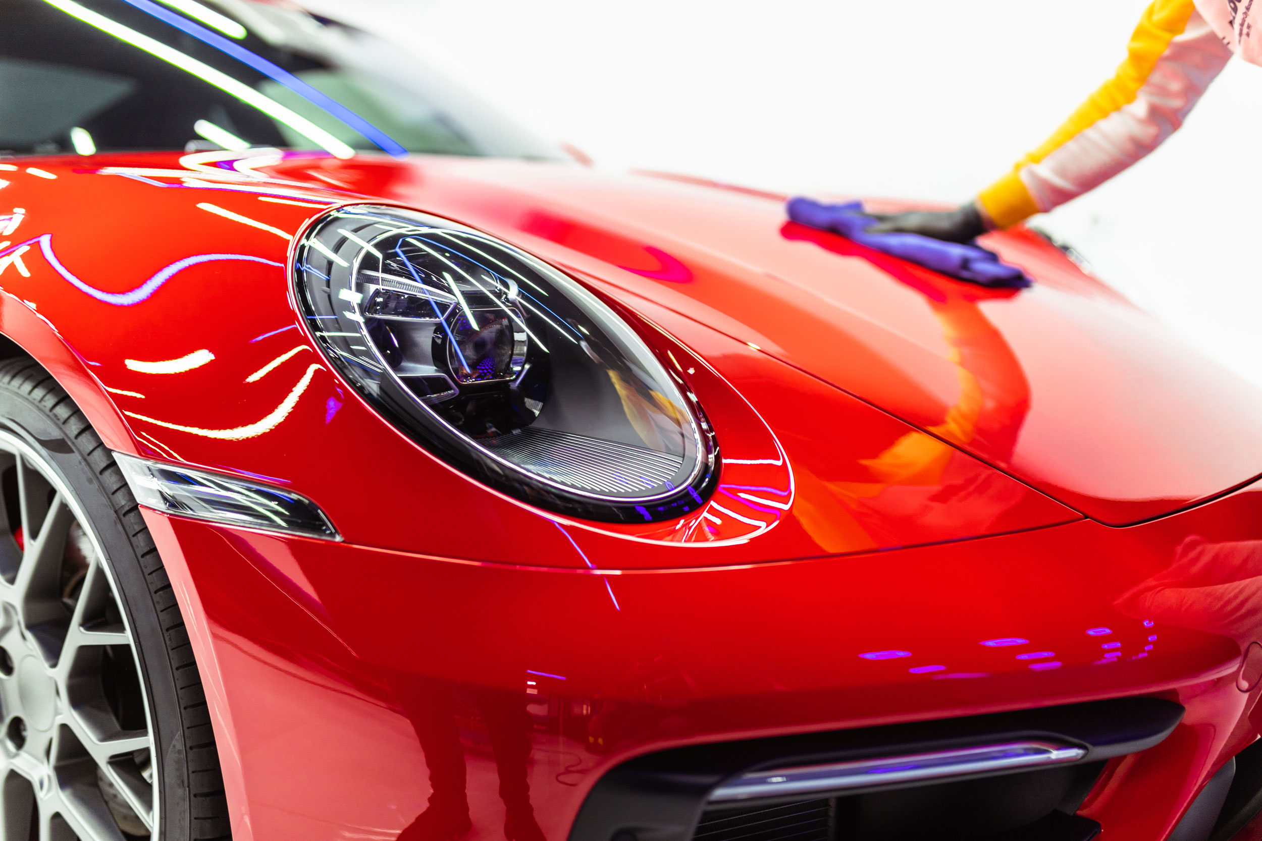 Freshly polished red Porsche 911 being detailed